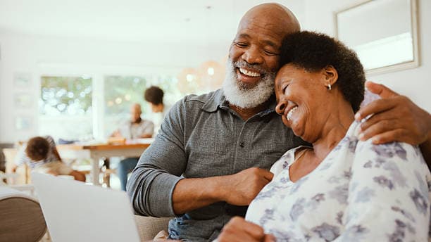 An elderly couple laughing together